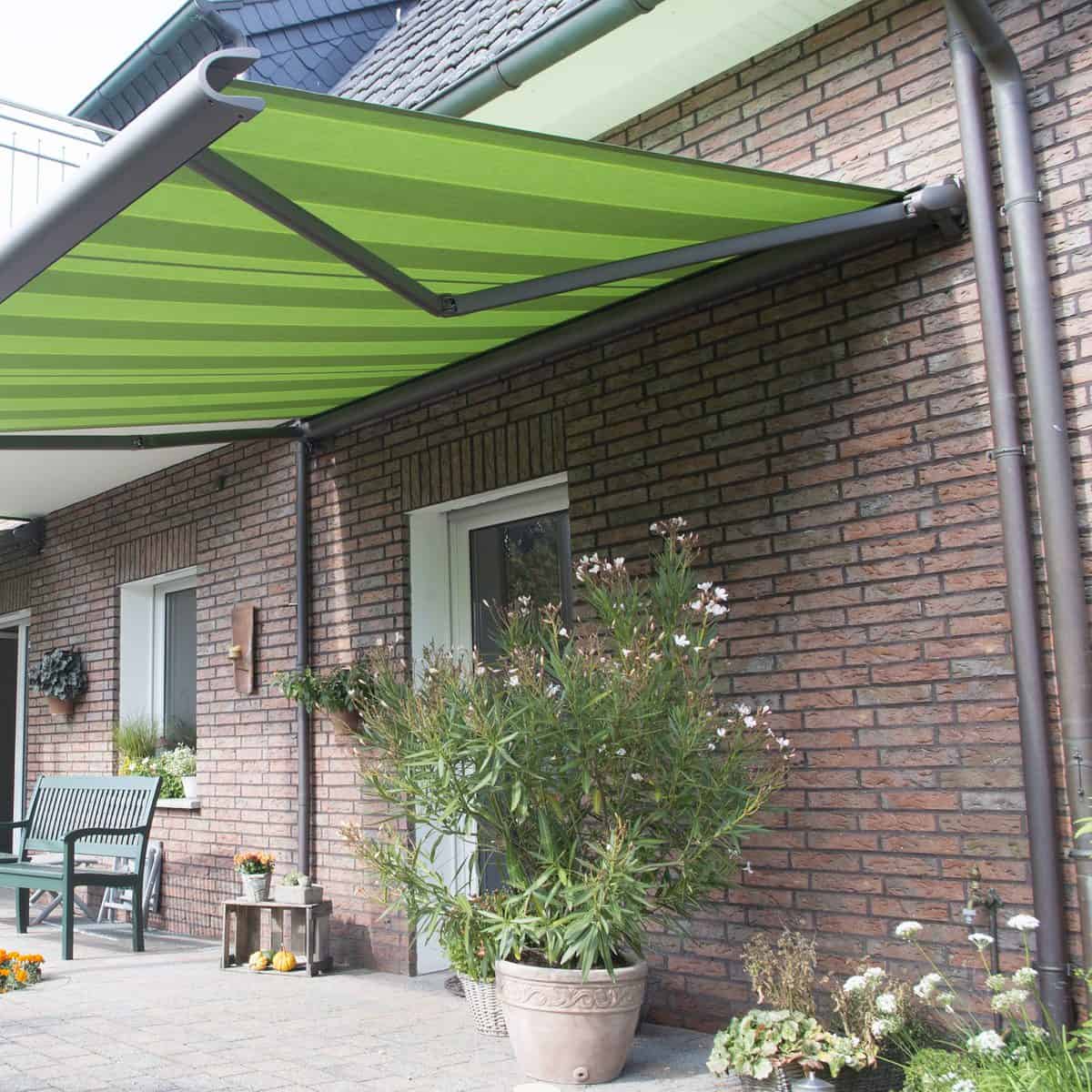markilux 990 awning in green stripes, attached to a wall on a house