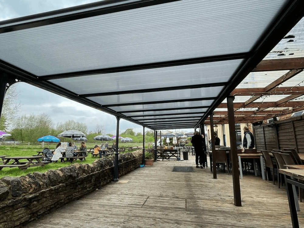The Milwood Simplicity 16 glass roof spanning 11.5m x 3.5m provides an elegant and spacious outdoor dining and entertainment area at a pub in Oxfordshire.
