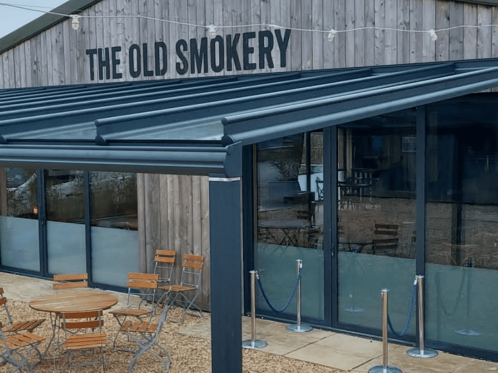 The Old Smokery in Cheltenham features a 10m x 4.8m Weinor Originale glass roof, providing an elegant and spacious outdoor dining area for guests to enjoy.