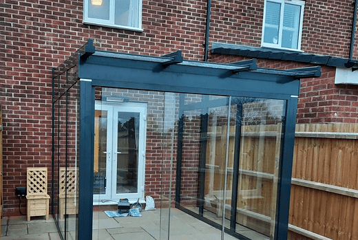 The Weinor Terrazza Sempra Plus glass room fitted in Warwickshire offers a versatile and stunning outdoor living space, with its glass sides and sliding glass door, providing both style and functionality to be enjoyed all year round.