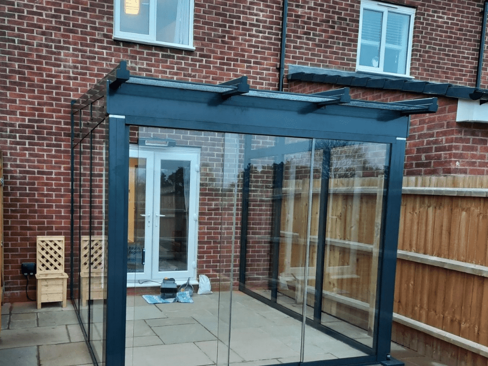 The Weinor Terrazza Sempra Plus glass room fitted in Warwickshire offers a versatile and stunning outdoor living space, with its glass sides and sliding glass door, providing both style and functionality to be enjoyed all year round.