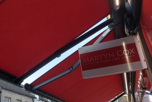 The customized Weinor Cassita II awnings in Oxfordshire, color-matched to the shop sign, provide the perfect upgrade to your commercial space, with remote control and wind sensors for easy and convenient operation, adding both style and functionality to your outdoor living space.