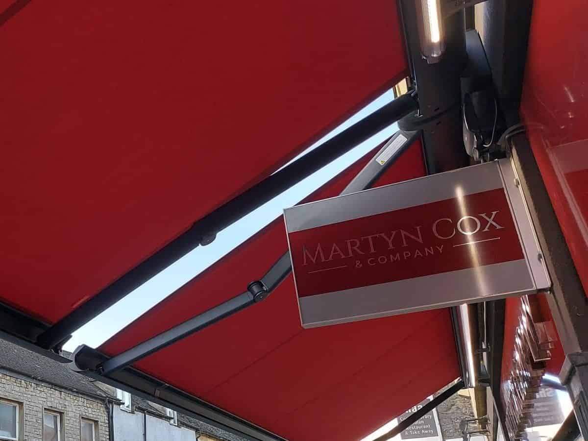 weinor Cassita II coupled awning colour matched to shop sign with remote control and wind sensors