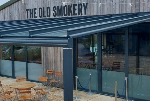 The Weinor Originale glass roof fitted to The Old Smokery in Cheltenham provides the perfect solution to elevate your outdoor living space, with an impressive size of 10m width x 4.8m projection, high-quality materials, and exceptional design and functionality, creating an enjoyable and stylish outdoor living experience.