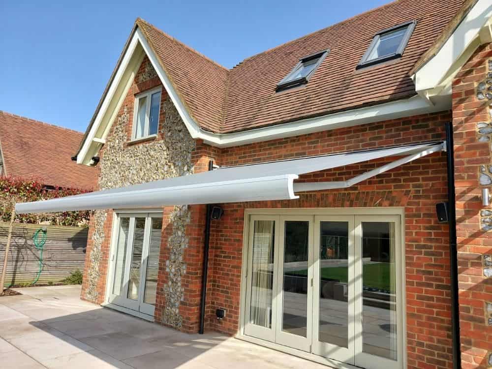 The Markilux MX-3 awning installed over a patio in Watlington provides a comfortable and convenient outdoor living space with its remote control and wind sensor, allowing for easy operation and protection from the elements.