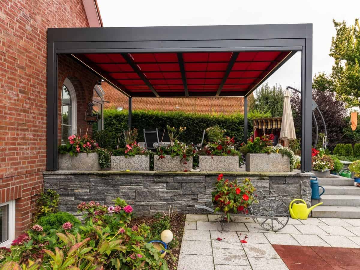 markilux markant pergola system over a patio in a bright red hue