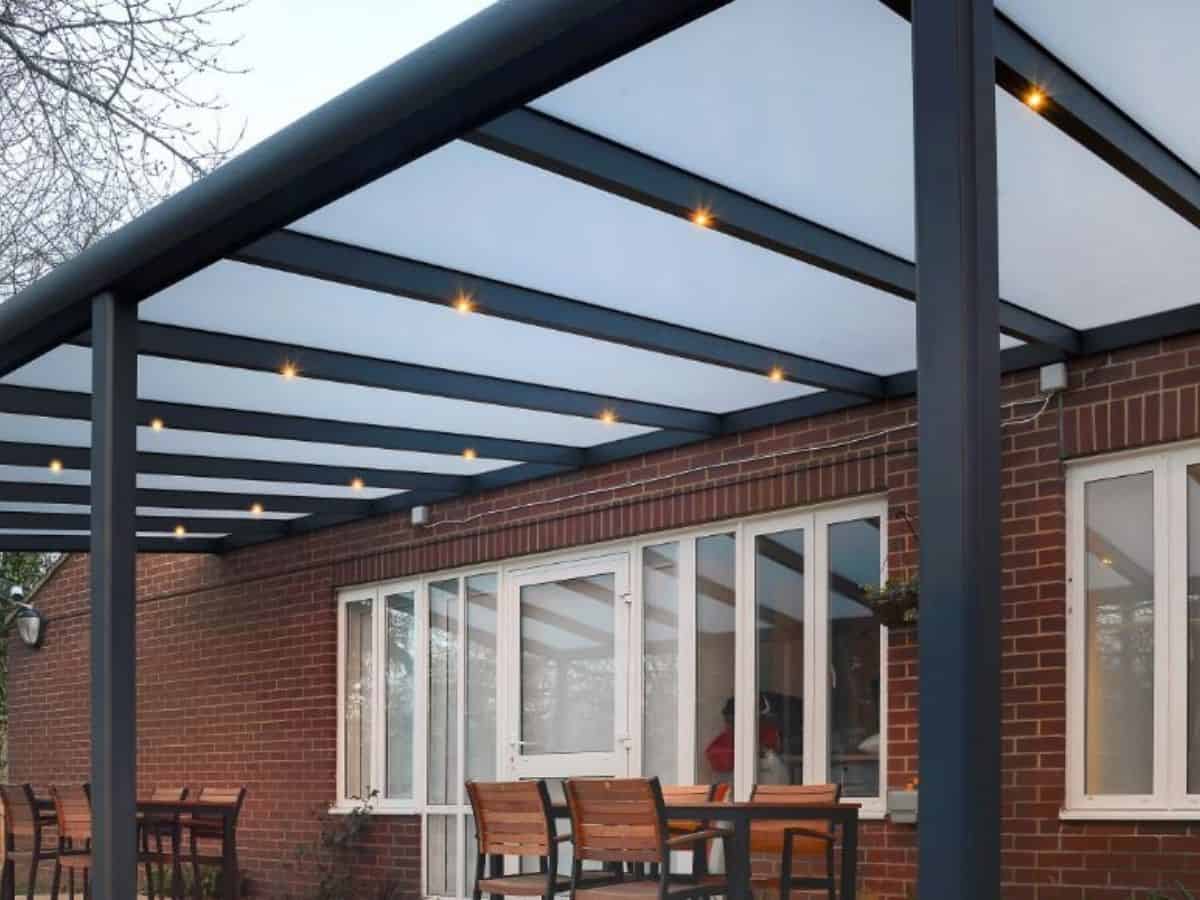 Cotswolds Modern wall mounted veranda attached to the back of a property with polycarbonate roof and LED spotlights