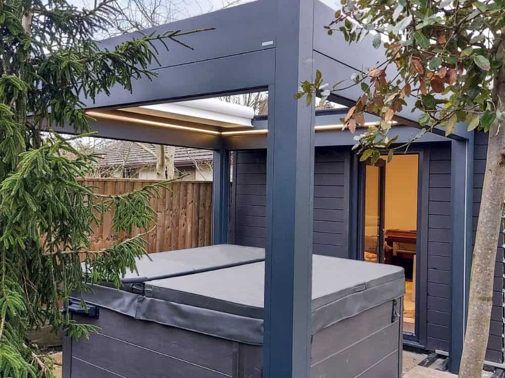 The Caribbean Blinds Prestige freestanding pergola with retractable roof and zip screen sides provides a comfortable and stylish solution to cover your hot tub in Wadebridge, allowing you to relax in style and comfort in your outdoor space.