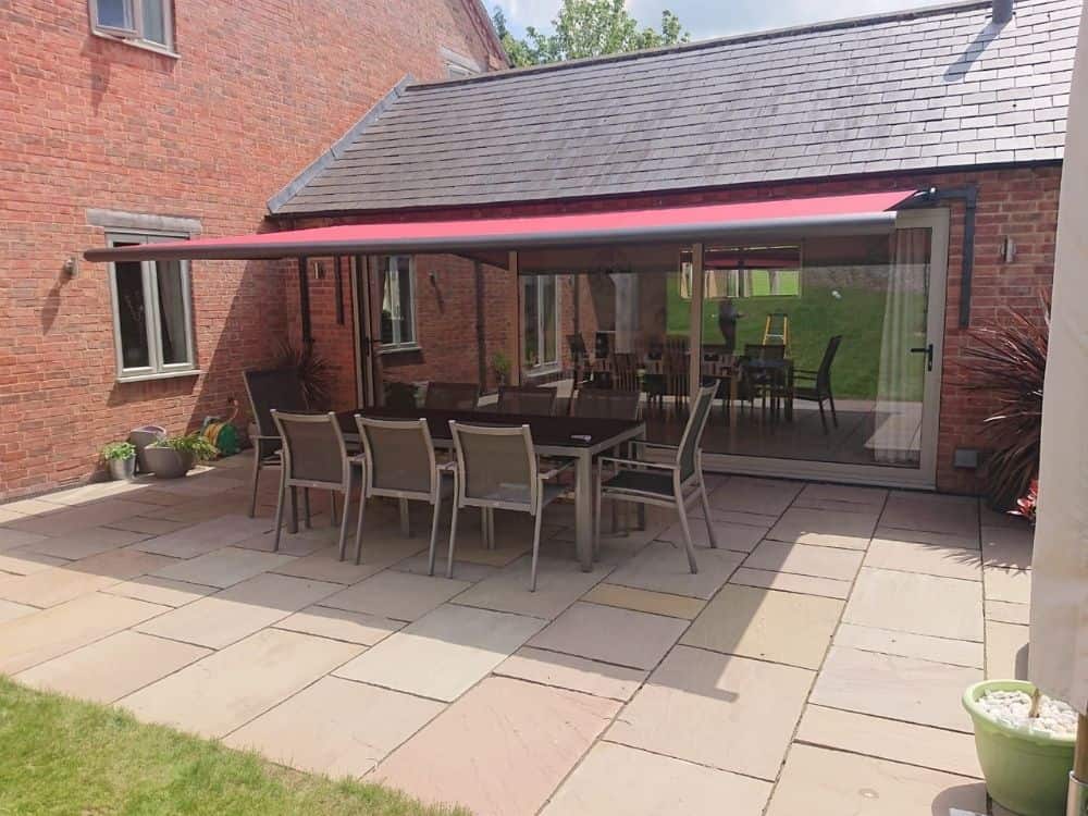 The Weinor Cassita II awning fitted to a house in Leicestershire with bespoke brackets provides a stylish and functional addition to your outdoor living space, with a neat fit underneath eaves on a single storey extension, allowing for an enjoyable and convenient outdoor living experience.