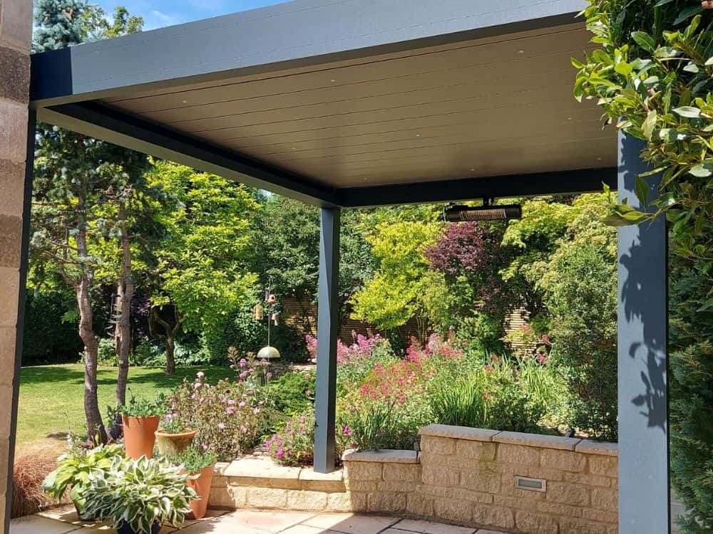 Freestanding pergola with Anthracite Grey frame and louvres, installed in Cirencester, Gloucs, featuring LED spotlights within louvres for evening illumination. Dimensions 2.8m width x 3m projection, 4 x 120mm posts.