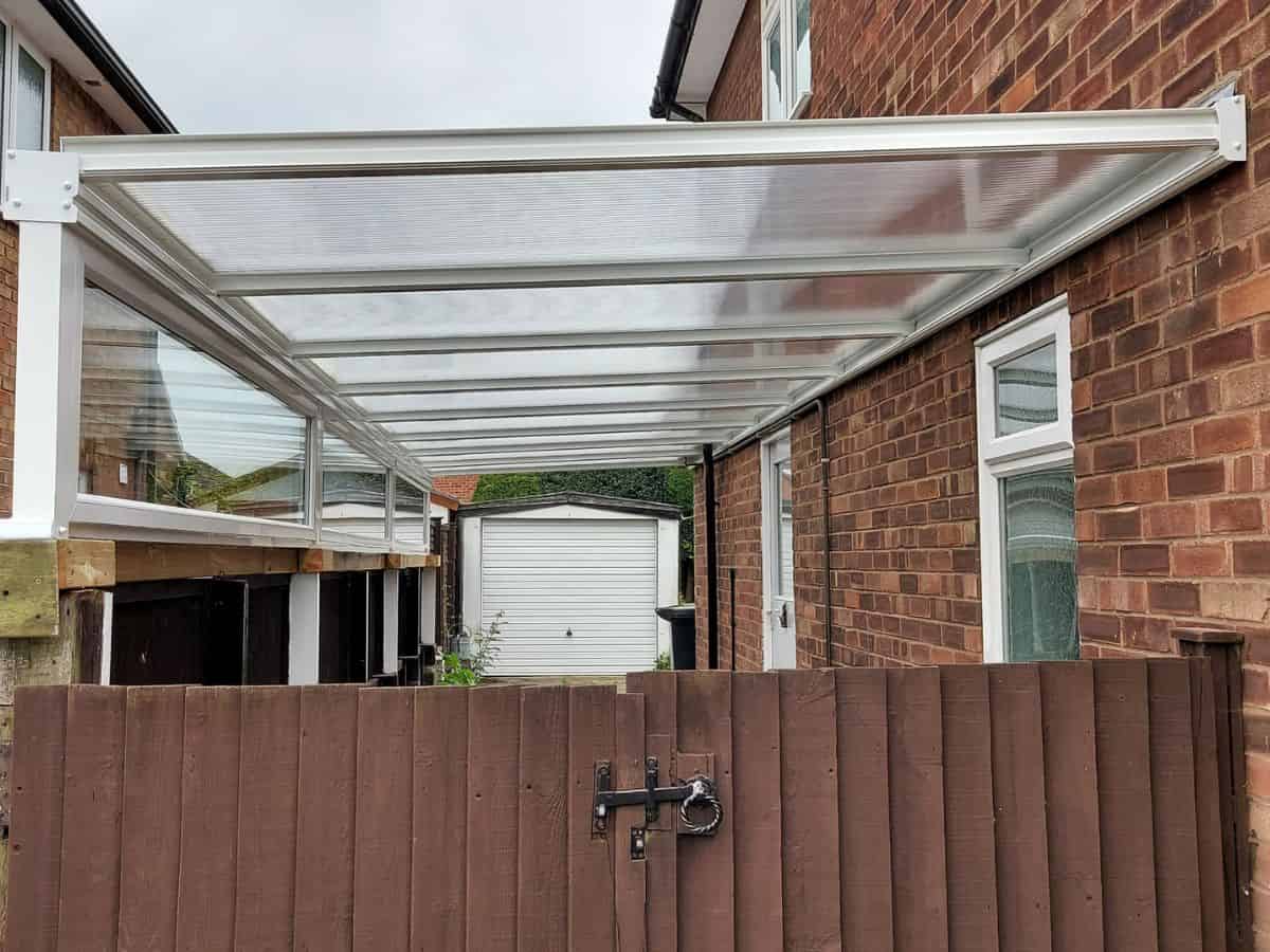 8m x 2.5m car port with Milwood 16 polycarbonate roof and 4 posts, 2 affixed to fence