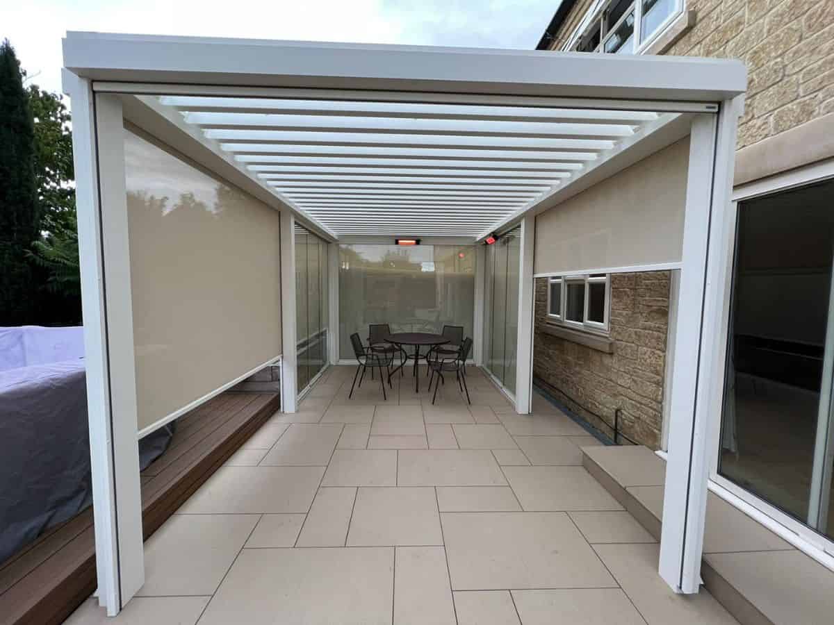 Tarasola Technic in white, with LED spotlights in the louvred slats, infrared heaters, glass sides and zip screens providing privacy. Fitted in Winchcombe