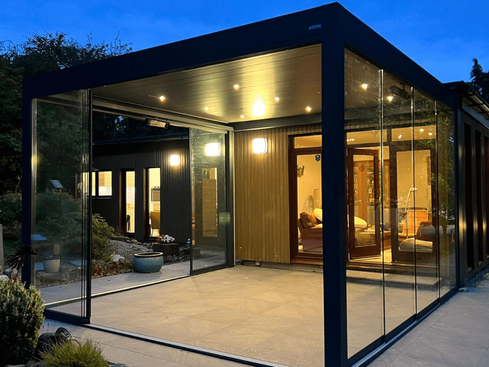 A Tarasola Technic glass room with louvred roof. The glass sliding sides allow the glass room to be accessed from outside. Integrated LED lights and infrared heater means it can be used all year round. Installed in Derbyshire