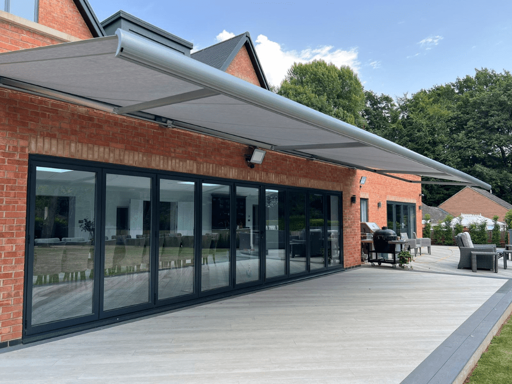 The Markilux 5010 awning in Warwickshire covers a large portion of the decking area with its impressive 10m width and 4m projection, providing both style and functionality to backyard living.
