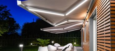 KE Qubica Plum twin awning with LED lighting in the arms wall mounted above patio area