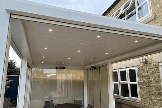 The Tarasola Technic louvred roof pergola in white provides both style and comfort with its 4 glass screens, zip screens, glass doors, LED lights, and infrared heater, making it a perfect choice for enjoying your outdoor space all year round.