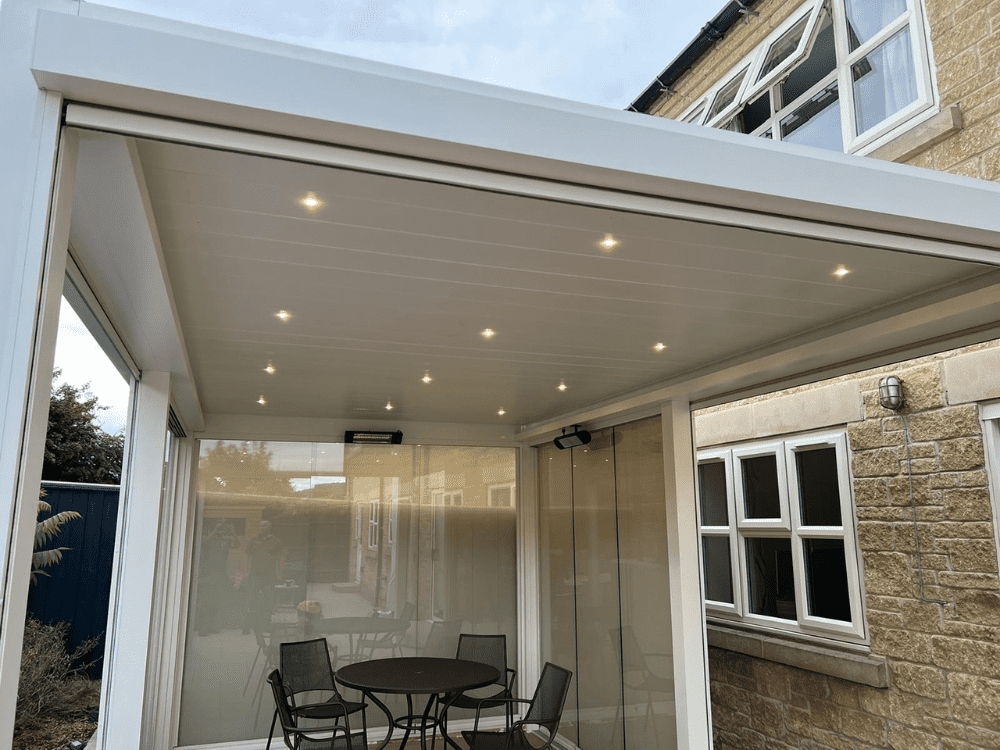 The Tarasola Technic louvred roof pergola in white provides both style and comfort with its 4 glass screens, zip screens, glass doors, LED lights, and infrared heater, making it a perfect choice for enjoying your outdoor space all year round.
