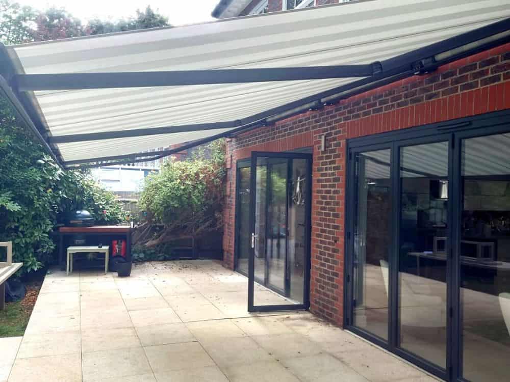 The Markilux 5010 awning installed at a home in Reading offers both convenience and comfort with its remote control and wind & rain sensor, providing a seamless and enjoyable outdoor living experience.