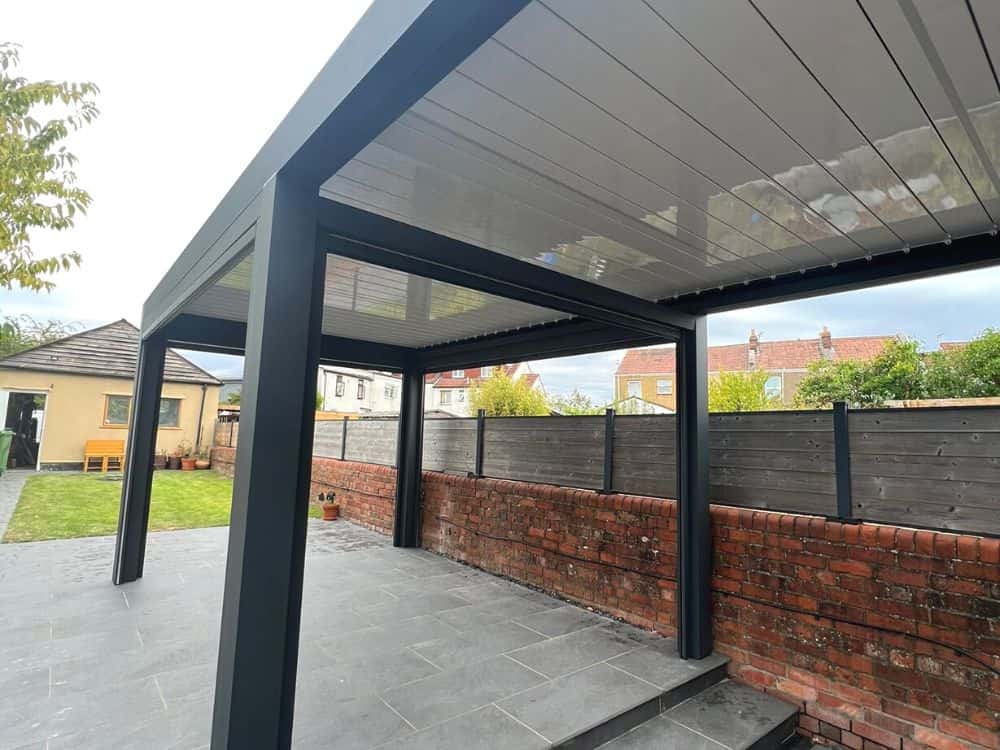 Two seesky bio louvred roof pergolas fitted to the back of a property in Bristol. The louvred roof is a gloss white, reflecting the LED lights installed into the sides of the pergola.