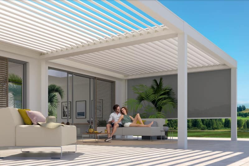 Enjoy the ultimate outdoor living experience with the Weinor Artares louvred roof pergola in white, as seen in this image featuring a couple relaxing in its shade on a sunny day. This pergola offers the perfect combination of style and function, with its solid construction and convenient louvred roof that provides shade and ventilation in all types of weather. Whether you're hosting a gathering or simply enjoying a peaceful moment, this pergola adds value and elegance to your outdoor space, allowing you to create lasting memories with family and friends.