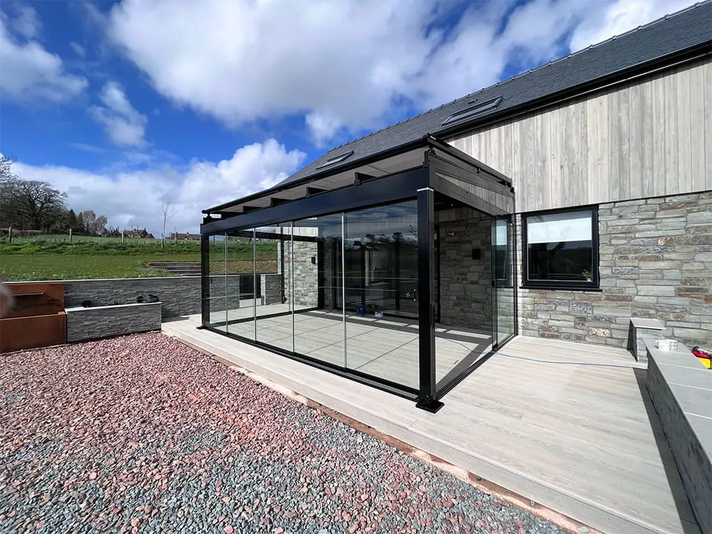 Glass room with over awning for perfect outdoor living space by Cotswold Awnings and Pergolas