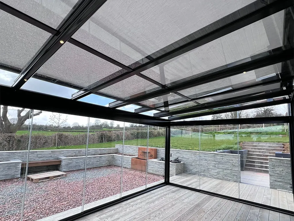 Glass room with over awning for stylish outdoor living by Cotswold Awnings and Pergolas