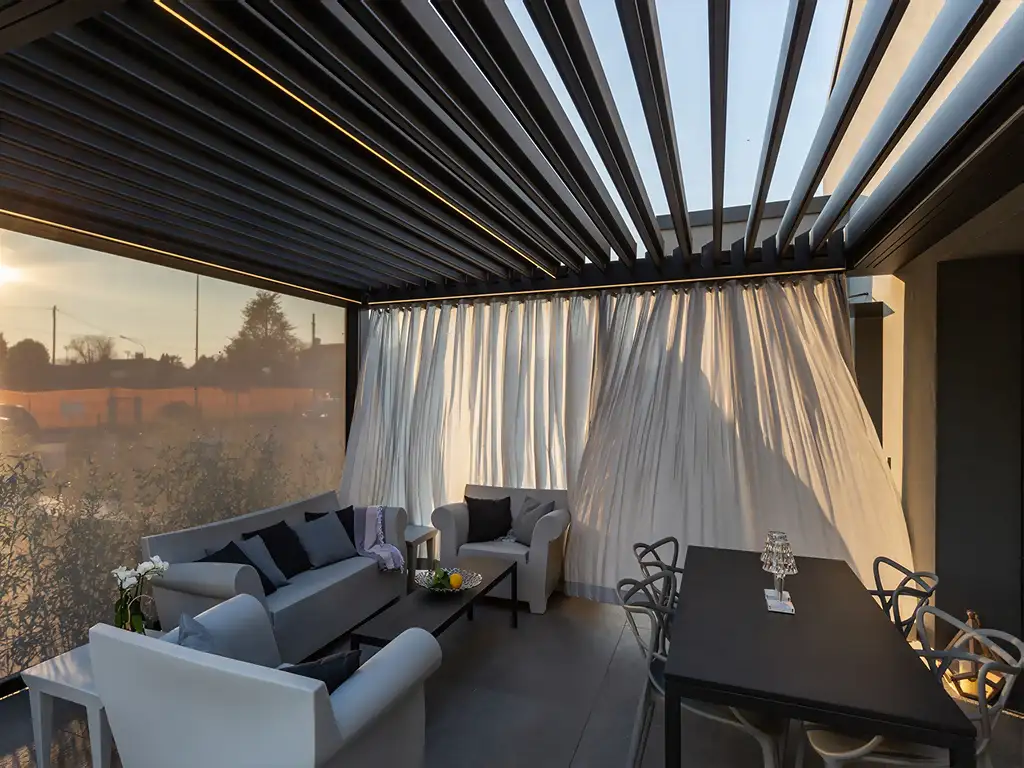 Ke Outdoor Design Kedry Prime Louvred Roof Pergola on patio with curtains blowing in the wind