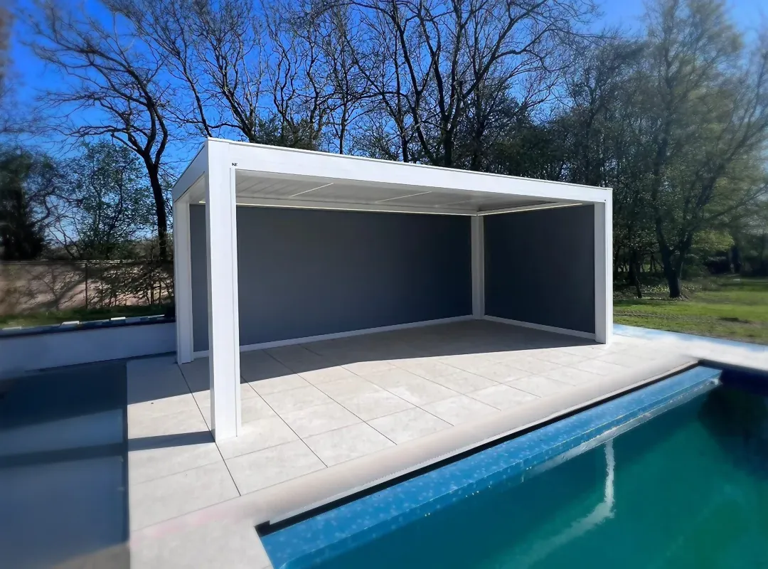 Front view of the installed KE Kedry Prime louvred roof pergola with the swimming pool in the background and the zip screens down, offering a private and cozy outdoor area.